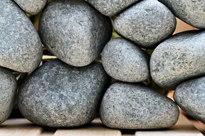 Premium gray sauna stones showing proper size variation and dense igneous rock texture for optimal heat retention and steam production