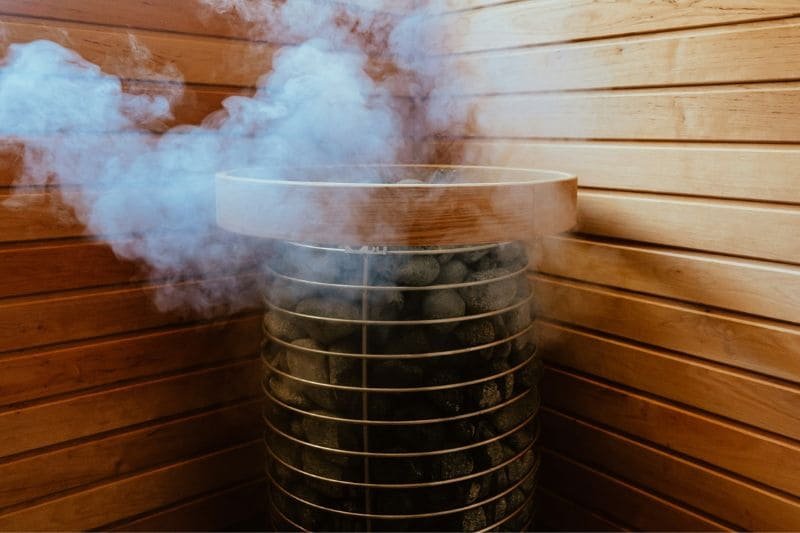 Steam rising from sauna stones in a traditional sauna