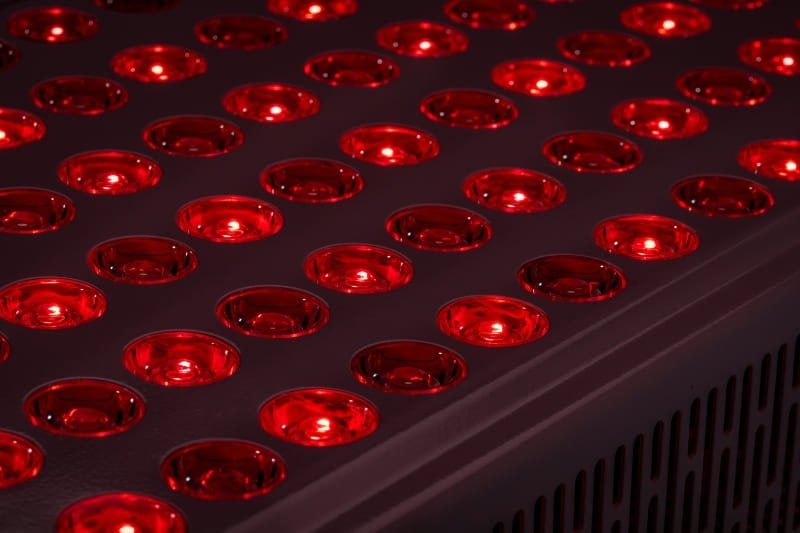 Close-up view of a red light therapy panel showcasing the illuminated red LED lights, indicative of the technology used in red light therapy