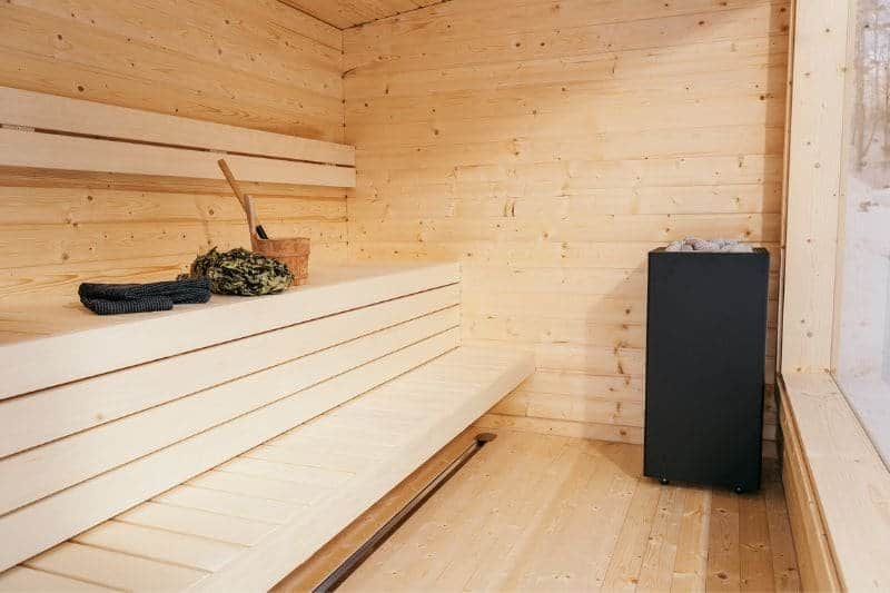 The warm, inviting interior of a traditional wooden sauna with neatly arranged benches, highlighting the simplicity and heat of the sauna experience.