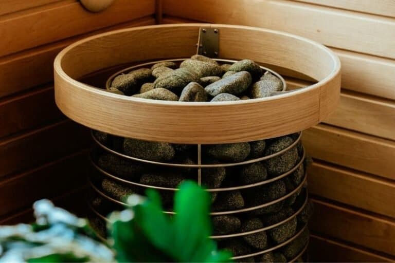 Close-up of sauna heater stones within a wooden sauna, highlighting efficient heater sizing."