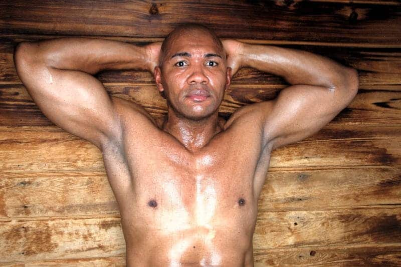 Individual reclining in a sauna, exemplifying a sweat session for detoxification and wellness.