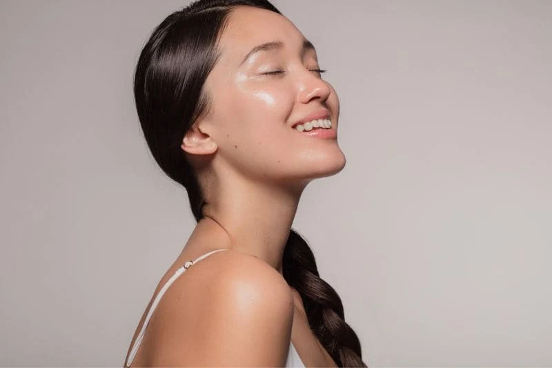 A woman's face with radiant skin showcasing the skin benefits of using an infrared sauna.