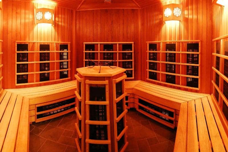 Infrared sauna interior made from cedarwood, with built-in benches and ambient lighting.