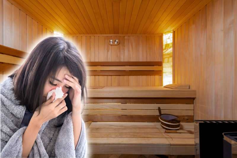 A woman with a cold, wrapped in a blanket and holding a tissue, with a traditional sauna in the background. This image highlights the concept of using a sauna when sick to alleviate symptoms.