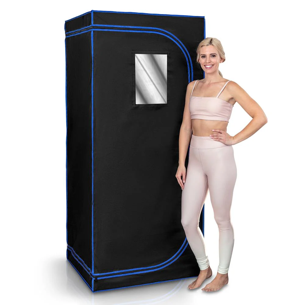 Woman standing next to the SereneLife Portable Infrared Sauna, showcasing its size and design.