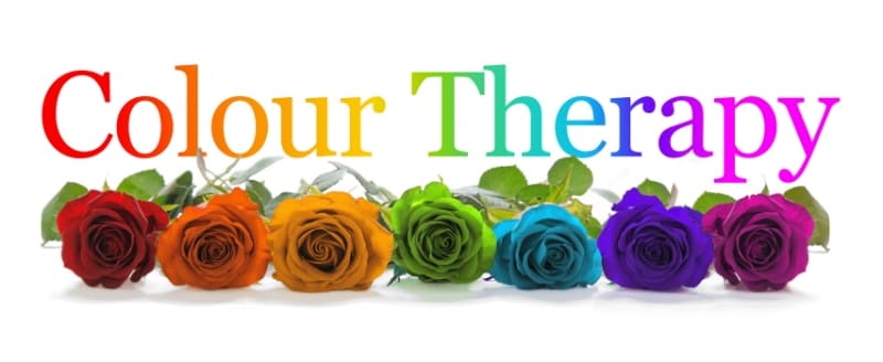 Color Therapy concept with vibrant roses representing different colors, including red, orange, yellow, green, blue, purple, and magenta, symbolizing various therapeutic benefits of chromotherapy.