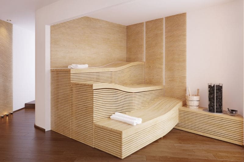 Contemporary sauna design with unique curved wooden benches, creating a wave-like aesthetic in a light-filled space