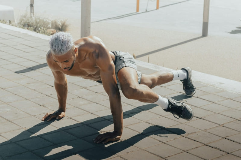 A man performs a challenging core exercise outdoors, demonstrating the importance of physical fitness