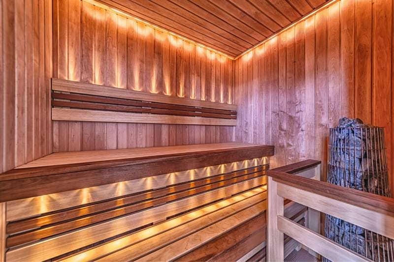 Modern sauna interior with sleek wooden panels and ambient LED lighting, showcasing contemporary sauna lighting design.