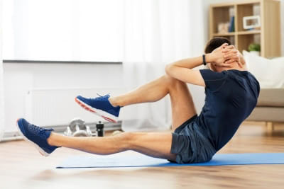 Person performing seated bicycle crunch exercise to strengthen core muscles