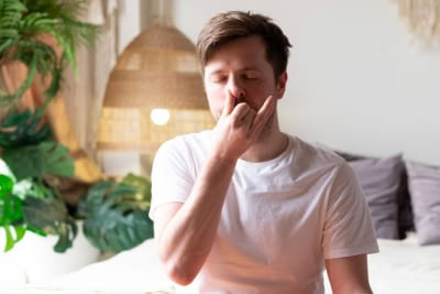 Man practicing alternate nostril breathing exercise for sauna relaxation and stress relief