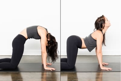 Woman demonstrating cat-cow pose for improved spinal flexibility in sauna yoga routine