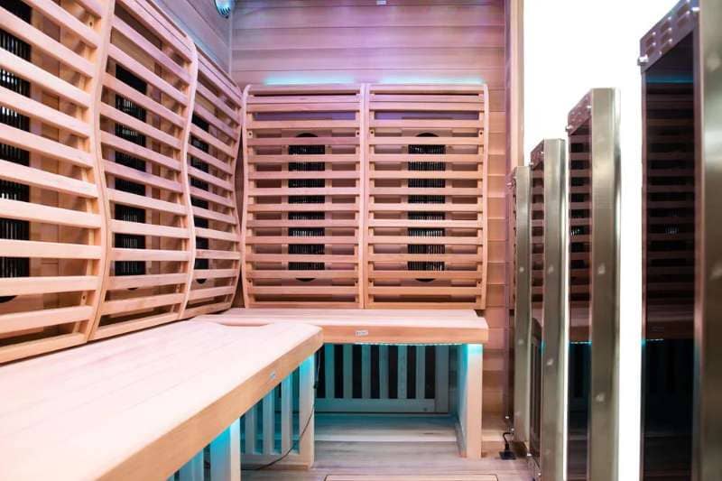 Interior of an infrared sauna showing wooden benches and infrared heater panels