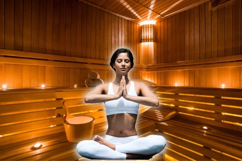 Woman practicing sauna yoga in meditation pose, demonstrating mindfulness and relaxation in a sauna environment