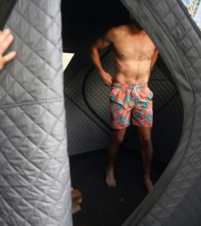 Person demonstrating interior space of Sweat Tent Portable Outdoor Sauna