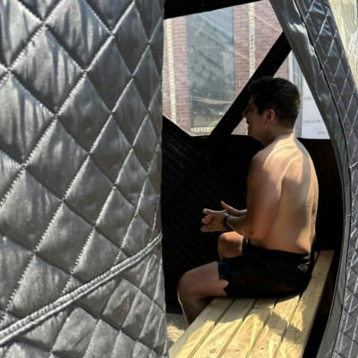 Person inside Sweat Tent Portable Outdoor Sauna, showcasing spacious interior