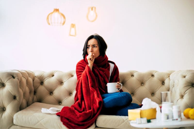 Woman with cough and cold symptoms drinking hot tea for relief