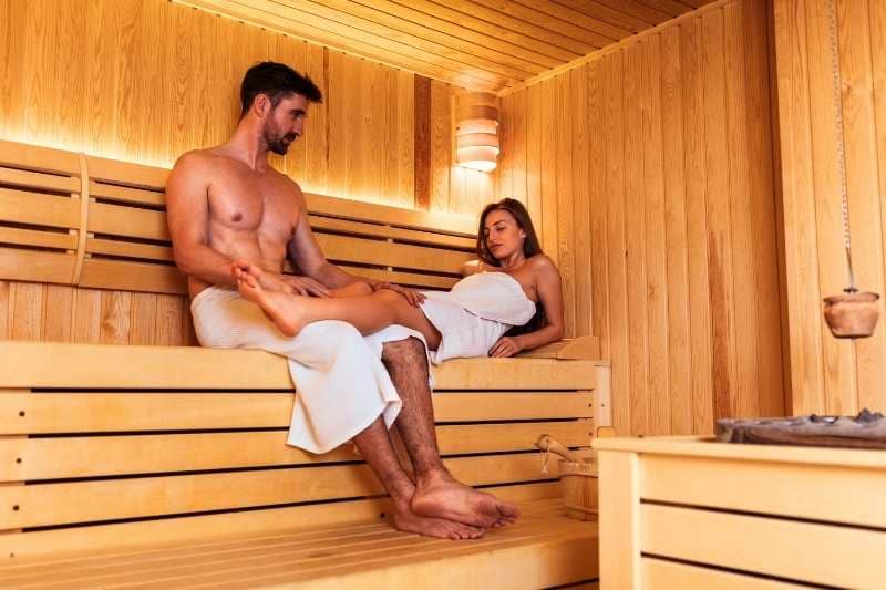 Man and woman experiencing sauna therapy, possibly enhancing circulation and overall wellbeing