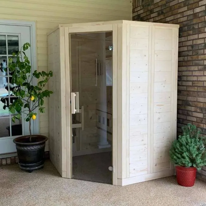 Space-efficient 2-person sauna installed on a porch, featuring a glass door and light wood finish