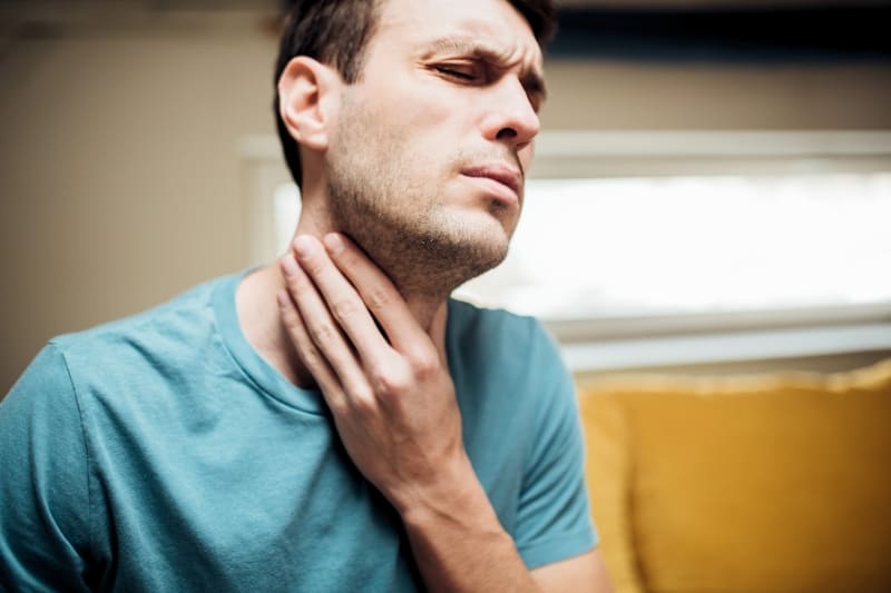 Man suffering from severe throat pain and inflammation