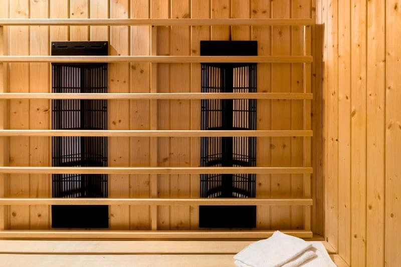 Modern infrared sauna interior featuring wooden panels and black heating elements