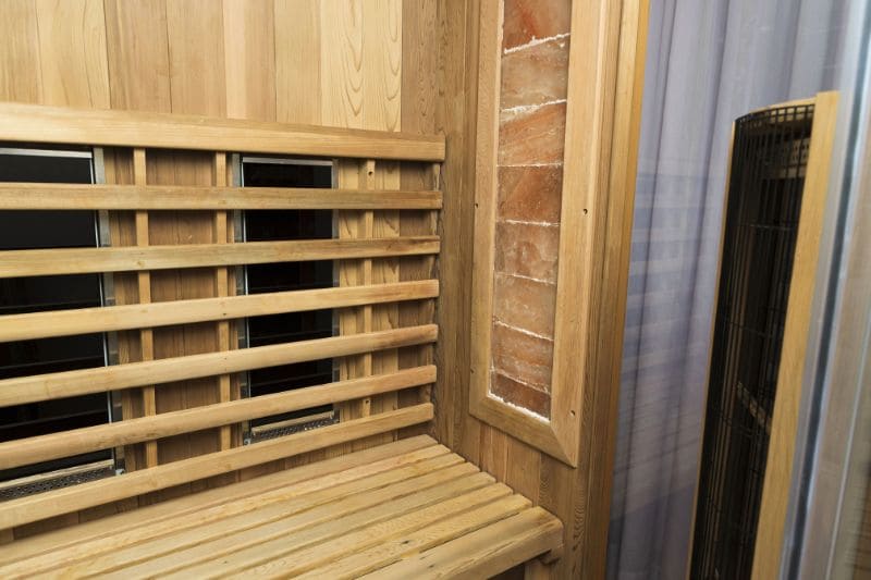 Close-up view of infrared heating panels and wooden bench in modern sauna, showing detailed construction