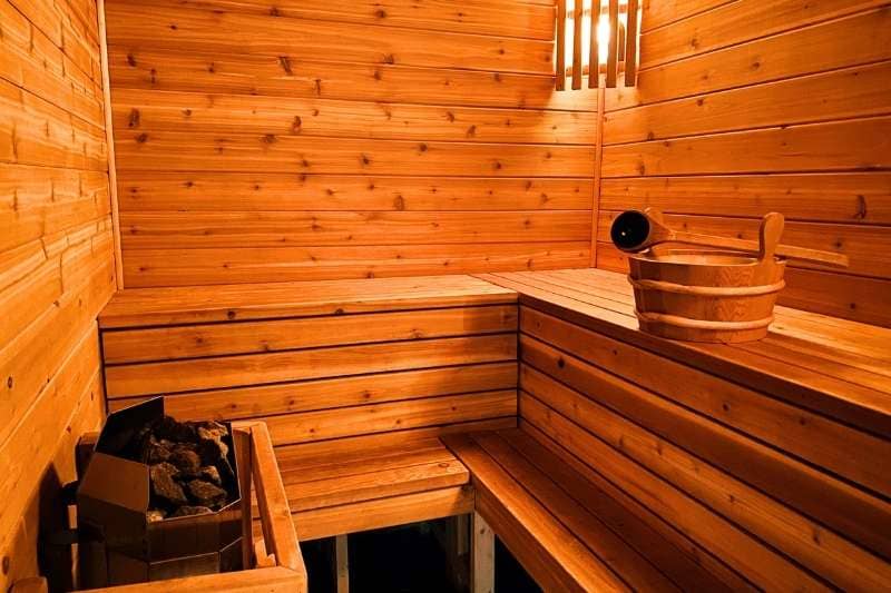 A clean and polished wooden sauna interior with evenly stained panels and warm ambient lighting.