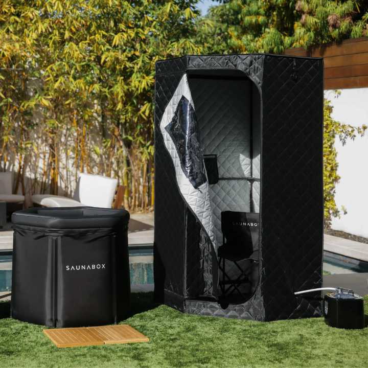 Saunabox personal sauna set up outdoors with the Plungebox (cold plunge) near a pool