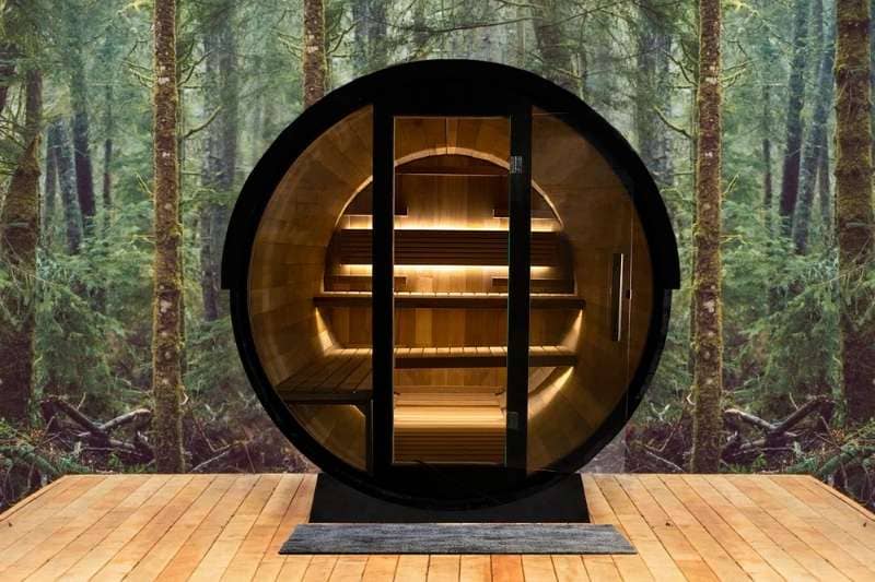 A beautiful barrel sauna nestled in a forested environment, creating a cozy and immersive wellness experience