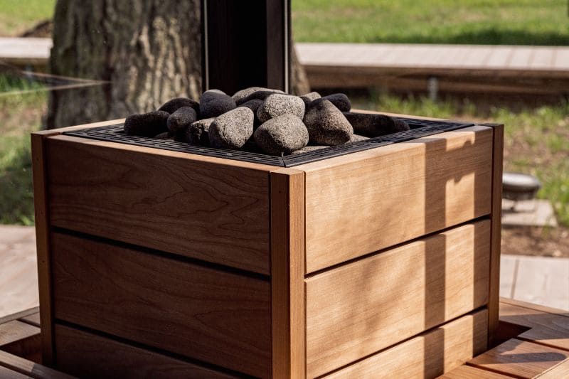 Sleek wooden box-style sauna heater with dark heating stones