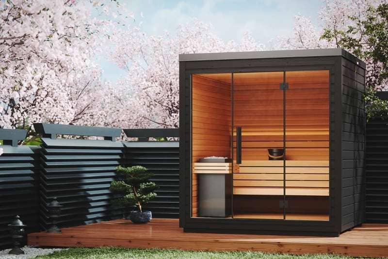 Outdoor traditional sauna surrounded by cherry blossom trees, offering a tranquil and relaxing atmosphere.