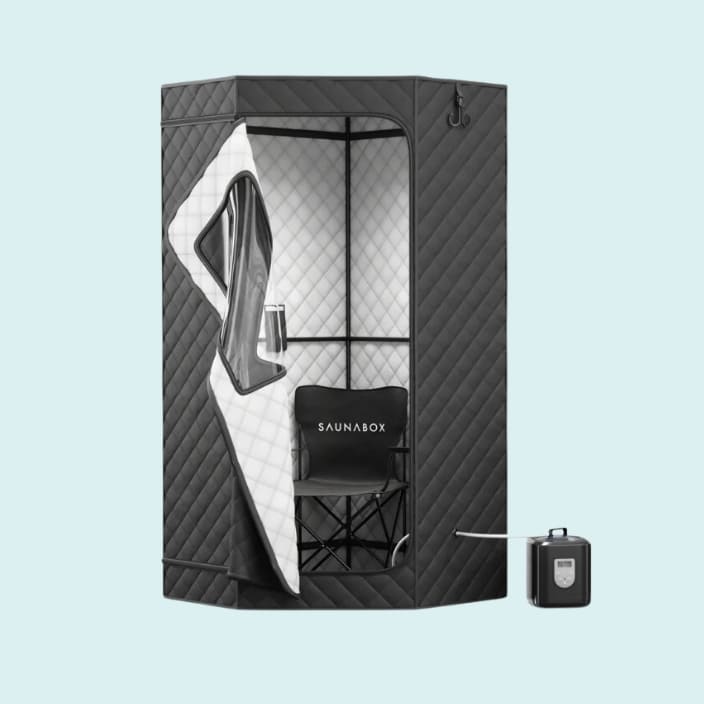 Saunabox portable steam sauna with quilted insulation panels, a foldable chair inside, and a steam generator outside