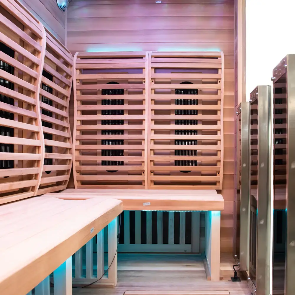 Interior view of ergonomic cedar backrests and infrared heating panels in Sun Home Luminar 5-person infrared sauna with ambient lighting