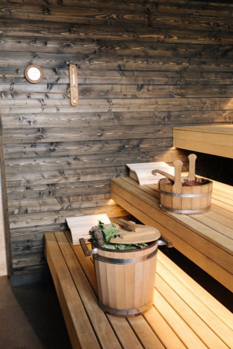 Interior details of a traditional sauna showing wooden buckets, ladle, and other accessories.