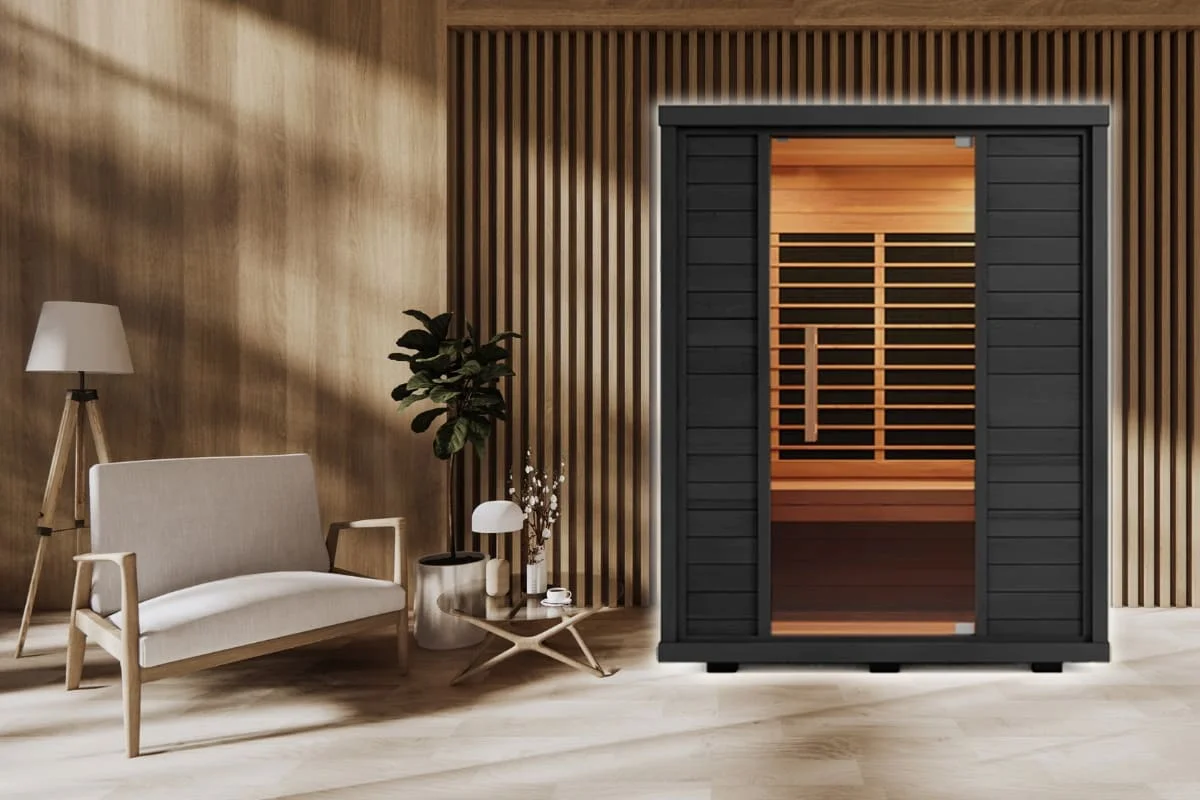 A modern infrared sauna in a stylish home interior, showcasing the best infrared sauna setup for relaxation and wellness. The sauna features a black exterior with warm interior lighting, blending seamlessly into the contemporary living space.