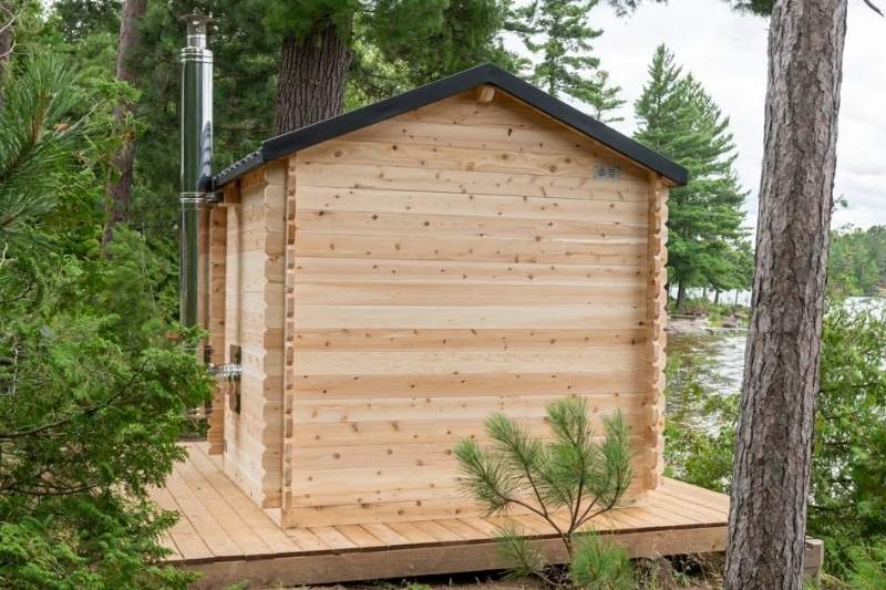 Back view of Dundalk CT Georgian cabin sauna with stainless steel chimney near lake