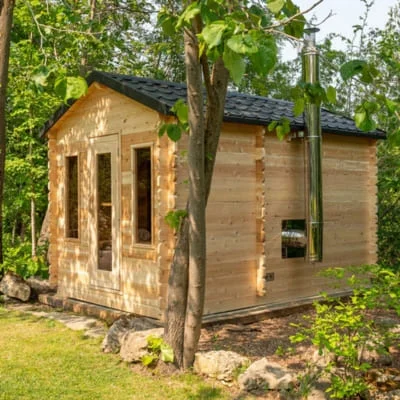 Dundalk CT Georgian 6-person sauna with changeroom featuring cedar exterior and black metal shingle roof in natural setting