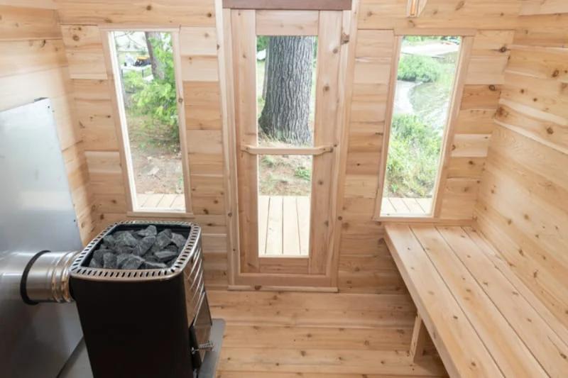 Dundalk CT Georgian sauna interior with multi-level benches, panoramic windows, and glass door with wooden frame