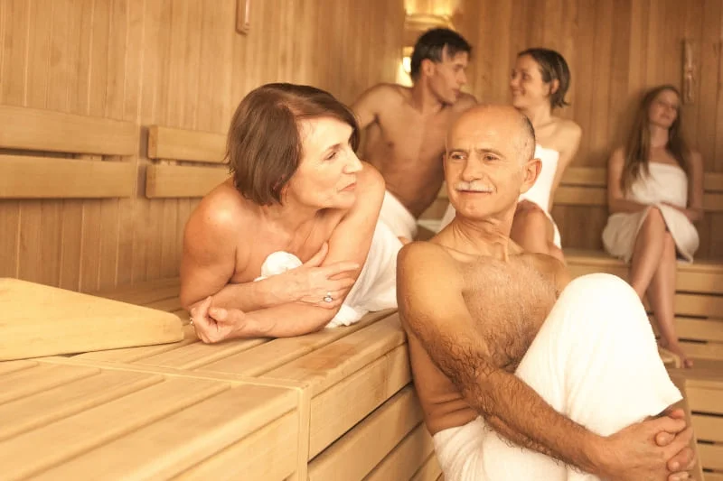 Seniors enjoying social interaction during sauna session, demonstrating the cognitive benefits of communal sauna use and social engagement