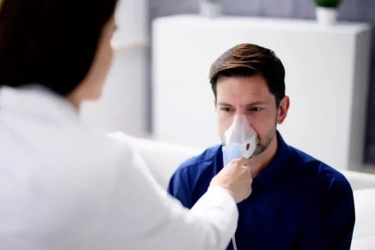 Healthcare provider administering nebulizer treatment to patient with respiratory condition such as COPD or emphysema.