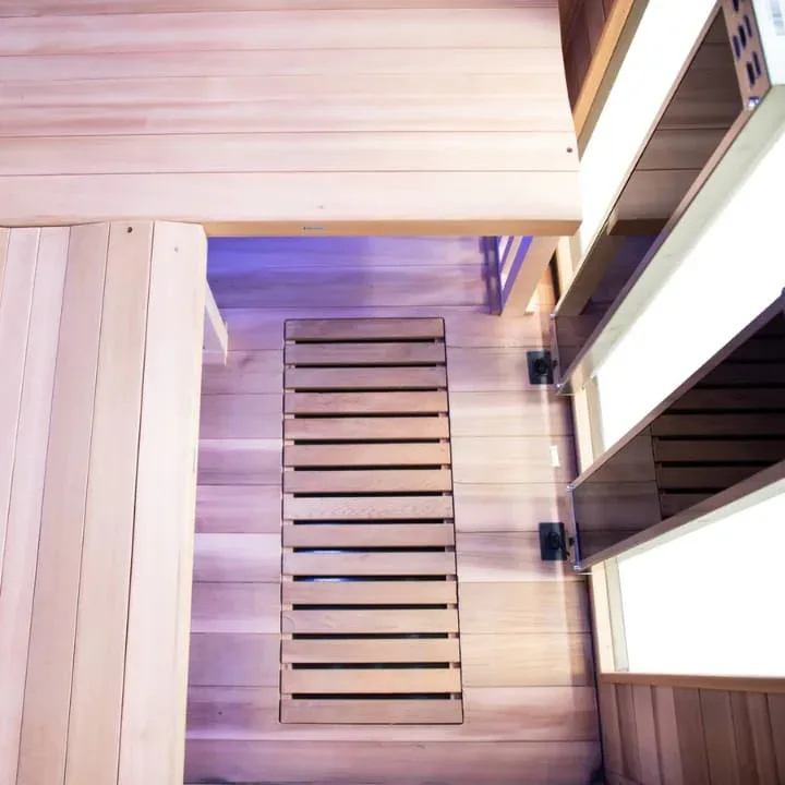 Sun Home Luminar 2-person infrared sauna with floor heating panels, wooden construction, and purple chromotherapy lighting for enhanced therapeutic benefits.