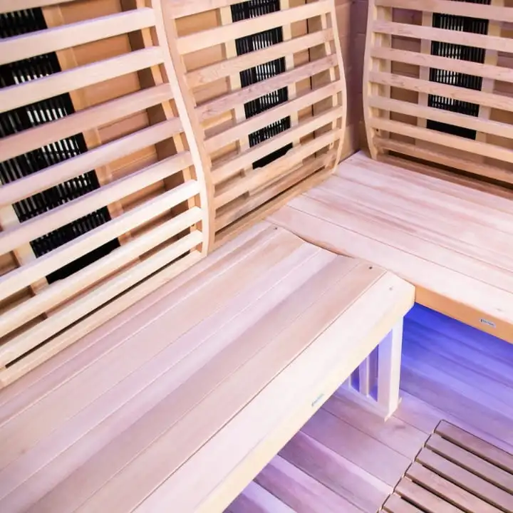 Sun Home Luminar infrared sauna wooden bench seating with carbon fiber heating panels and blue chromotherapy lighting for relaxation therapy.