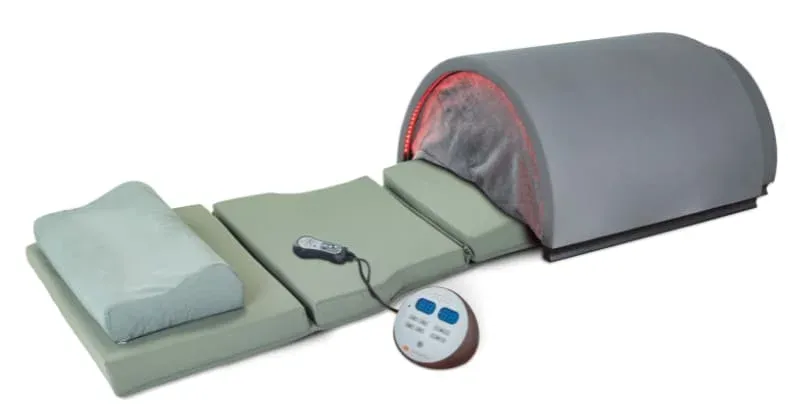 Fully extended Sunlighten Solo infrared sauna system with dome, memory foam pad, ergonomic pillow, and dual controllers, demonstrating its complete setup for therapeutic sessions