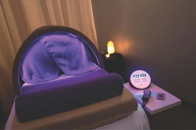 Sunlighten Solo portable sauna with purple chromotherapy in relaxing spa environment with ambient lighting.