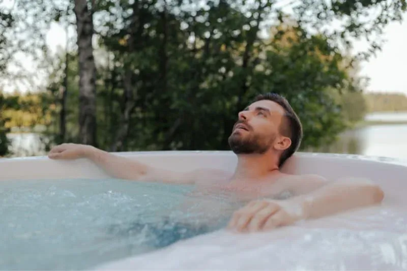 Man enjoying therapeutic hot tub session for stress relief and health benefits in outdoor spa