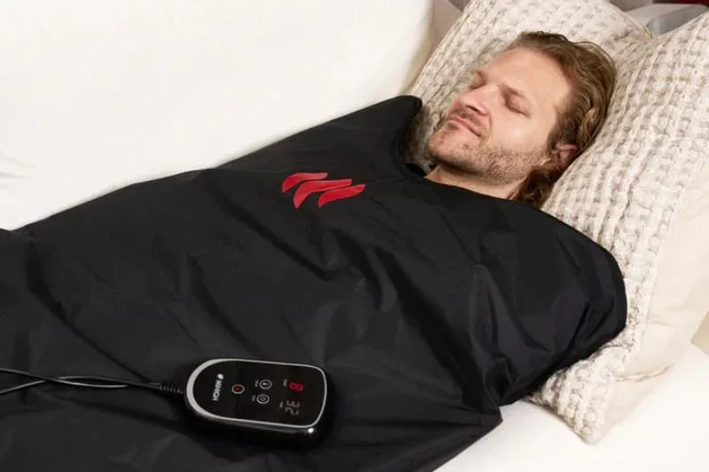 Man using MiHigh infrared sauna blanket in bed with digital temperature controller for relaxation and recovery