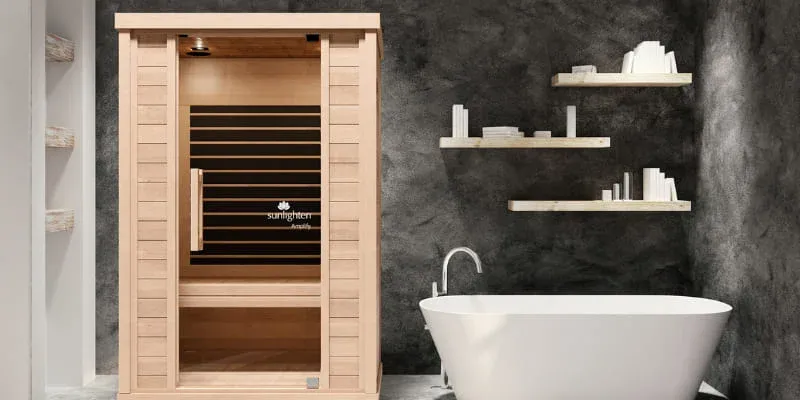 Sunlighten Amplify full spectrum sauna in modern spa bathroom with freestanding bathtub and dark accent wall