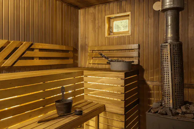 Modern sauna room with LED lighting, wooden construction, and traditional sauna accessories