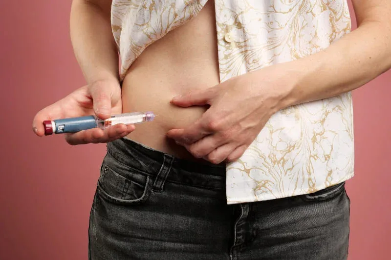 Woman injecting insulin injection pen for diabetes treatment and blood sugar control
